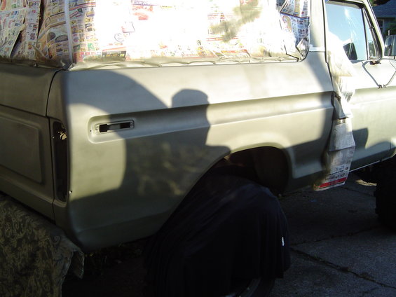 1978 Ford Bronco side view, primer gray, with newspaper masking on the roof
