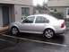 2001 Volkswagen Jetta - Side view of a silver 2001 Volkswagen Jetta sedan parked in a wet lot.