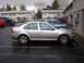 2001 Volkswagen Jetta - A silver 2001 Volkswagen Jetta is parked in a lot with other vehicles and apartment buildings in the background.