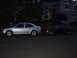 2001 Volkswagen Jetta - Two cars are parked on a street in front of a house as evening approaches.
