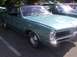 1970 Ford Ranchero - A teal 1967 Pontiac Firebird coupe is parked outdoors, with other vehicles visible in the background.