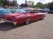 1970 Ford Ranchero - A red 1962 Chevrolet Bel Air is displayed at a car show with other vehicles in the background.