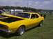 1970 Ford Ranchero - A yellow 1967 Chevrolet Camaro coupe is displayed with its hood open at an outdoor car show.