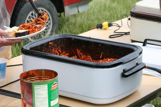 Red vehicle side view with white rim wheel, serving spaghetti from a crockpot