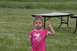 1990 Chevrolet Suburban - A young girl stands in a grassy field with tables in the background.