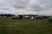 1990 Chevrolet Suburban - A gathering of vehicles and tents in a field on a cloudy day.