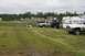 1990 Chevrolet Suburban - Several vehicles and a travel trailer are parked on a grassy field under an overcast sky.