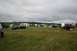 1990 Chevrolet Suburban - A gathering of vehicles and camping setups under a cloudy sky.