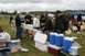 1990 Chevrolet Suburban - People mingle at an outdoor event with an abundance of beverages and coolers set up on the grass.