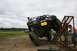 1990 Chevrolet Suburban - A modified Jeep Wrangler is shown at an extreme angle while climbing a metal ramp structure.