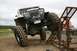 1990 Chevrolet Suburban - Custom off-road vehicle attempting an obstacle at an event.