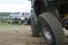 1990 Chevrolet Suburban - Multiple off-road vehicles are lined up, with a focus on the tire and suspension of the closest vehicle.
