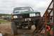 1990 Chevrolet Suburban - A green pickup truck is parked on a dirt surface, with a winch mounted on its front bumper.