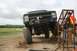 1990 Chevrolet Suburban - This heavily modified truck, likely from the 1980s, is positioned at an angle on a dirt track, ready for an off-road event.
