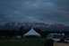 1990 Chevrolet Suburban - An SUV is parked in a field with a tent and mountains in the background during twilight.