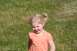 1990 Chevrolet Suburban - A young child with blonde hair in pigtails smiles while standing in a field of grass.