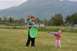 1990 Chevrolet Suburban - Two girls enjoy a game of frisbee in a grassy field with mountains in the distance.