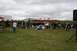 1990 Chevrolet Suburban - An outdoor event with attendees seated and standing under tents on a cloudy day.