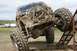 1990 Chevrolet Suburban - A heavily modified and mud-splattered off-road vehicle navigates a challenging obstacle course.