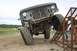 1990 Chevrolet Suburban - An off-road vehicle is positioned on a metal ramp, its modified suspension and large tires.