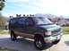 2001 Ford E150 - A modified Ford E-Series van sits parked in a driveway with mountains in the background.