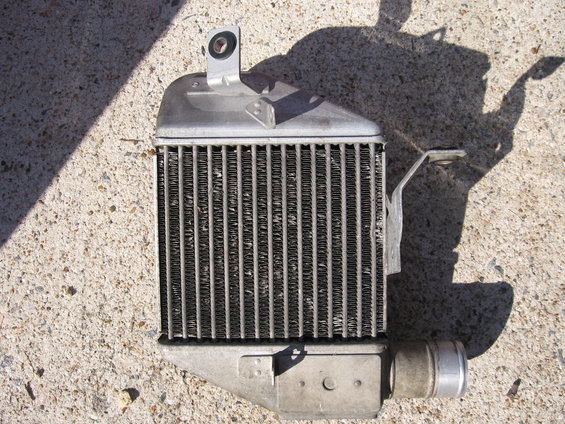 Intercooler with metal fins and aluminum tanks, mounted on concrete