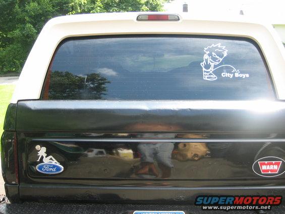 Rear of a Ford Bronco with a Ford logo sticker and a 'City Boys' sticker on the window