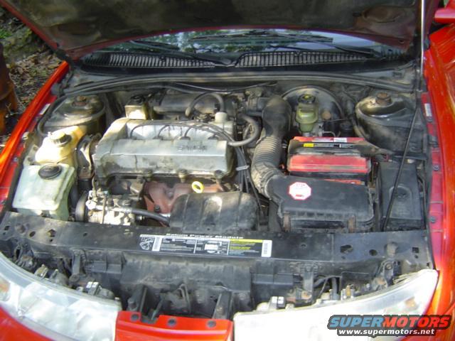 1997 Saturn SC engine bay with hood open, showing engine, battery, and air intake