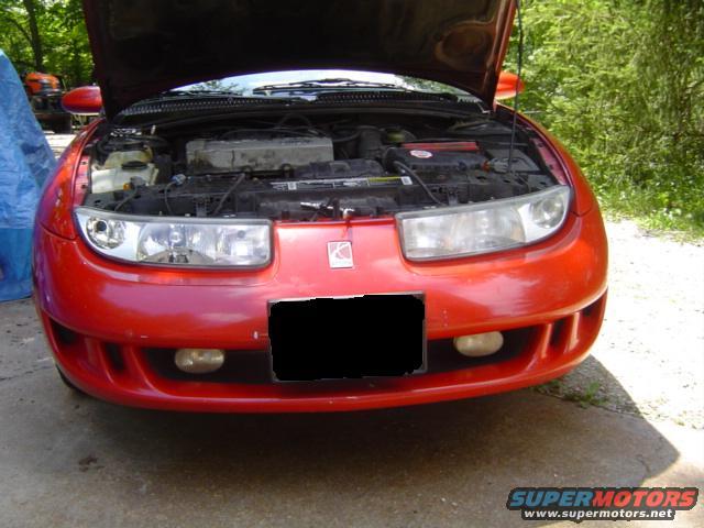 1997 Saturn SC front view, hood open showing engine bay. Blacked-out license plate area