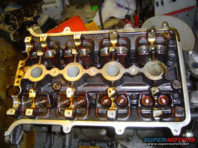 Engine valve cover with oil residue and visible valve train components