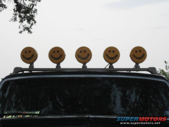 Roof rack with five yellow smiley face lights, each labeled 'DAYLIGHTER'