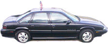 Black sedan, side view, with a flag on the roof and alloy wheels
