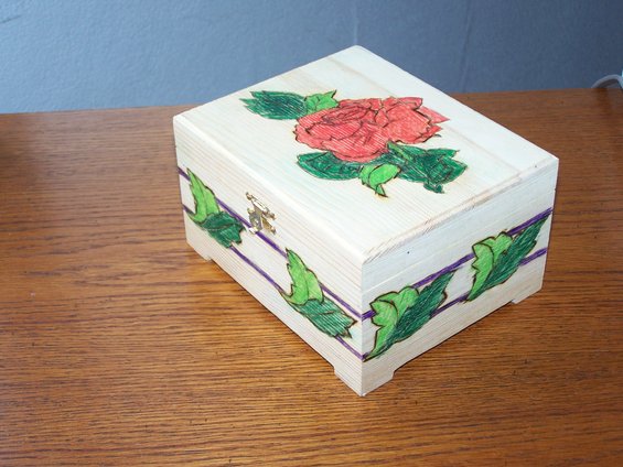 Wooden box with red rose and green leaves decoration