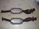 1997 Mercury Grand Marquis - Two exhaust catalytic converters are shown side-by-side on a patterned floor.