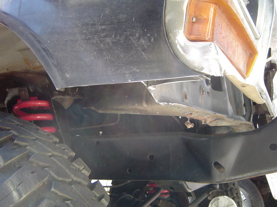 Front fender and suspension of a 1979 Ford Bronco, showing red coil springs and a large tire