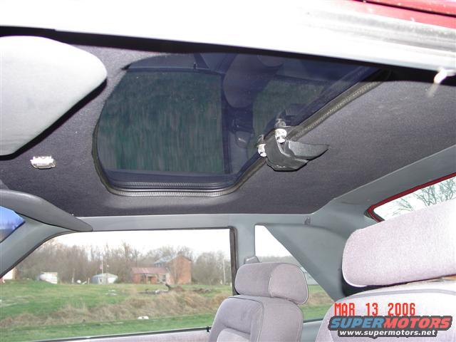 Interior view of a car's sunroof mechanism and headliner