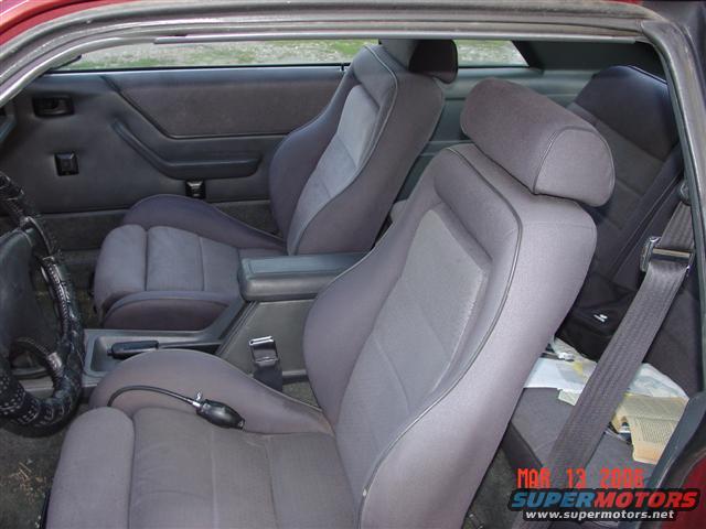 1984 Ford Mustang interior showing front bucket seats, rear seats, center console, and door panels