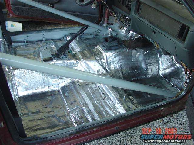 Interior of a 1984 Ford Mustang with sound deadening and roll cage