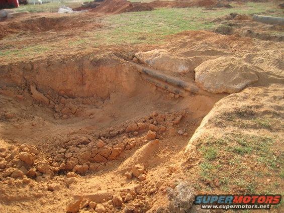construction site with dirt mounds and exposed pipes
