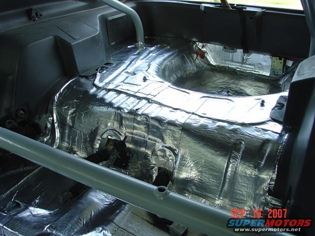 1984 Ford Mustang interior with sound deadening material covering the floor and transmission tunnel