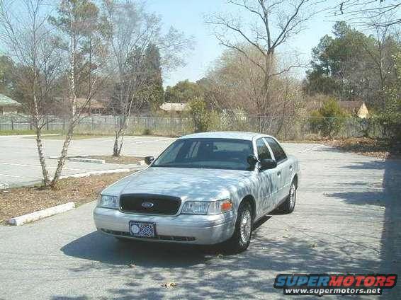 2001 Ford Crown Victoria parked in a lot with trees and buildings in the background