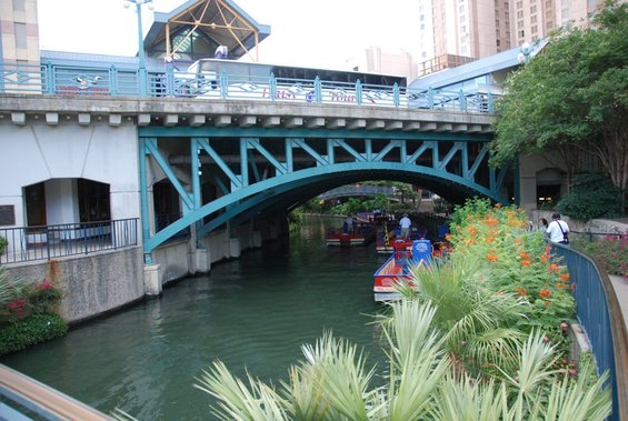 Riverwalk scene with tour boats passing under a bridge, San Antonio