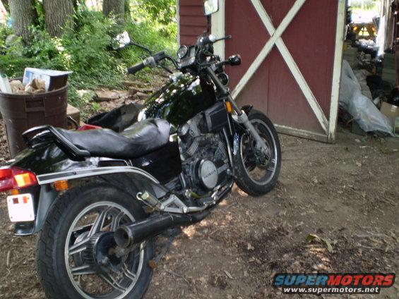 Black 1984 Honda VF700S motorcycle parked in front of a red barn
