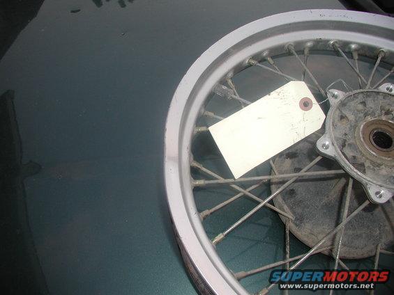 Motorcycle rear wheel with spokes and a white tag attached