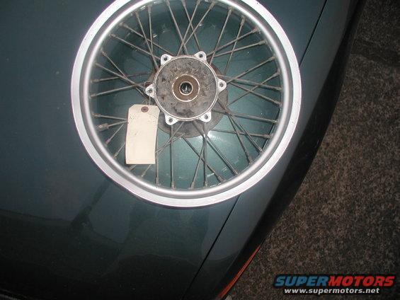 Motorcycle spoked wheel with a blank white tag attached to spokes