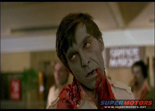 Zombie with bloodied neck and pale skin, looking towards the camera