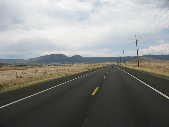 Motorcycles on a highway with mountains in the background