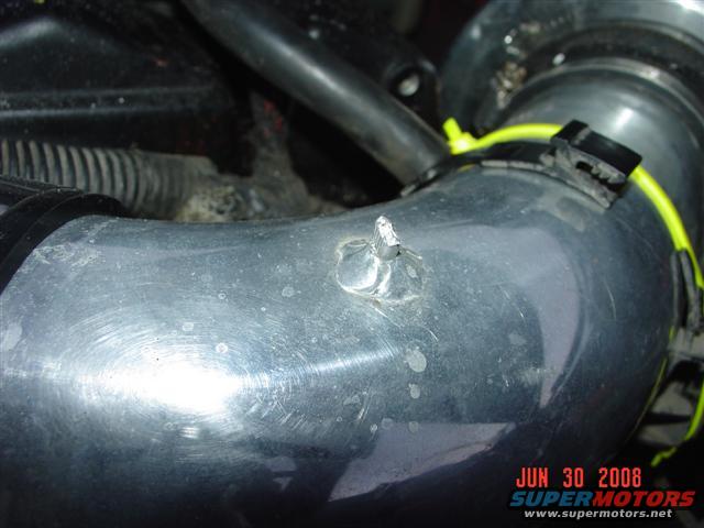 Aluminum intake tube with a yellow zip tie and a date stamp