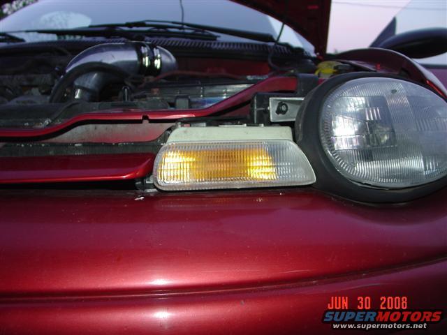 1997 Dodge Neon front end, hood open, showing engine bay details and headlight assembly