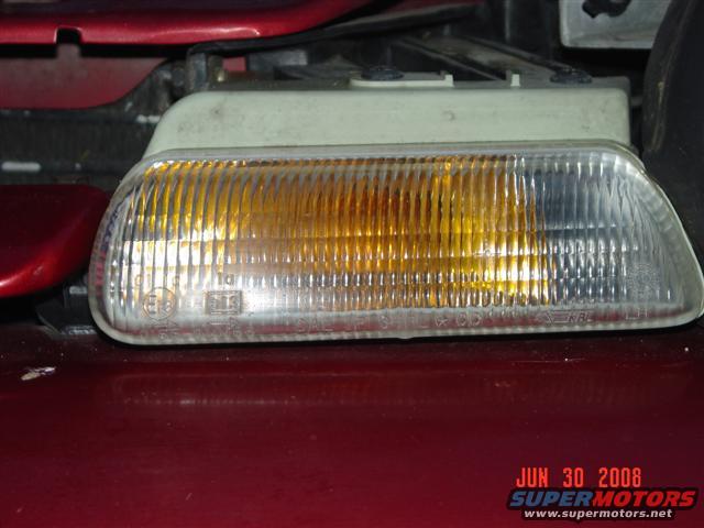 Close-up of a clear and amber car turn signal assembly with ribbed lens